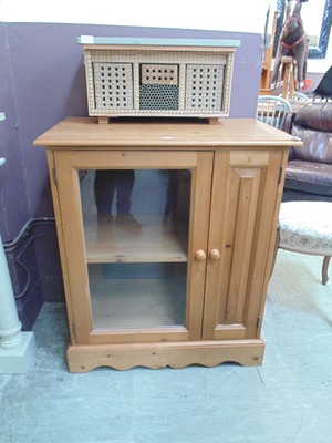 Lot 65 - A modern pine cabinet having a glazed door...