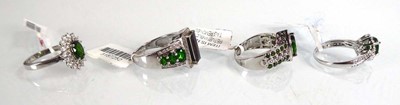 Lot 805 - Four silver dress rings set green and clear...