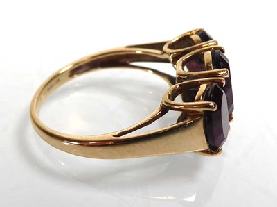 Lot A 9ct yellow gold ring set three oval purple...