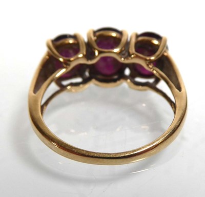 Lot A 9ct yellow gold ring set three oval purple...