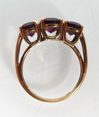 Lot A 9ct yellow gold ring set three oval purple...