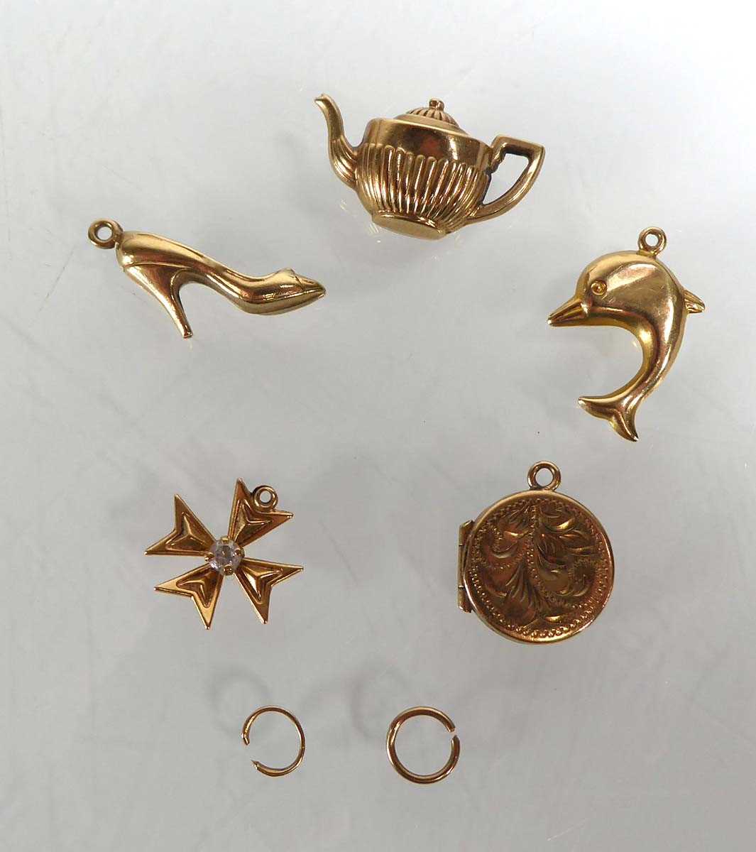 Lot Five 9ct yellow gold and yellow metal charms...