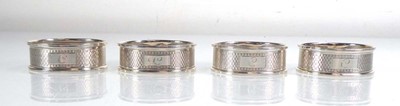 Lot 411 - A set of four silver engine turned napkin...