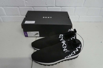 Lot 1132 - A boxed pair of DKNY slip on trainers in black....