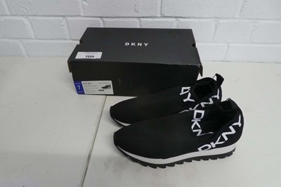 Lot 1135 - A boxed pair of DKNY slip on trainers in black....