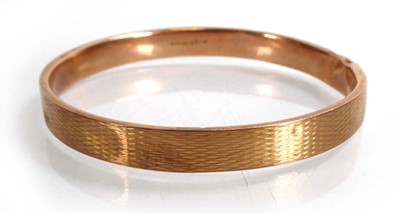 Lot A 9ct yellow gold engine turned slave bangle,...