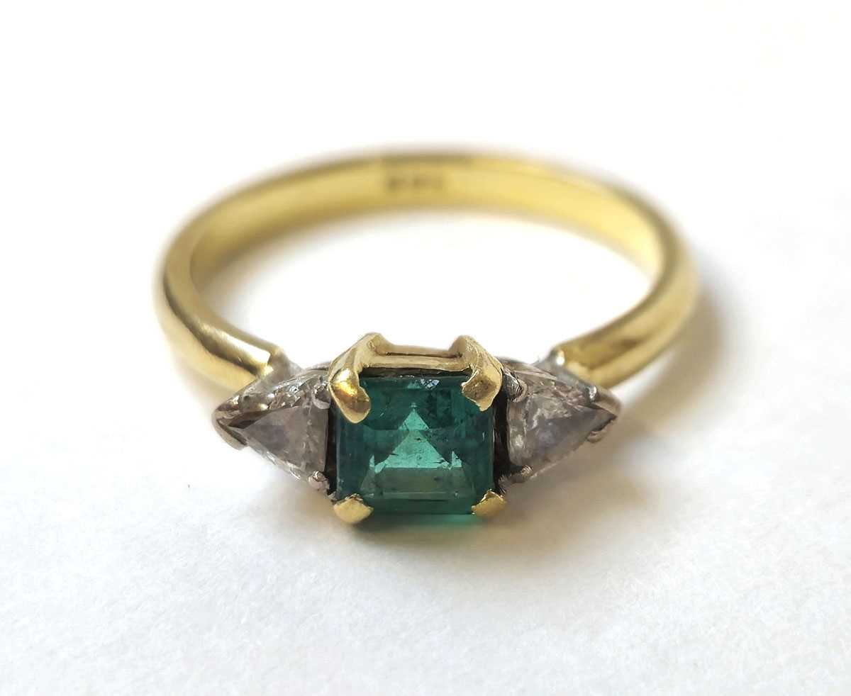 Lot 500 - A yellow metal, emerald and diamond ring. The...