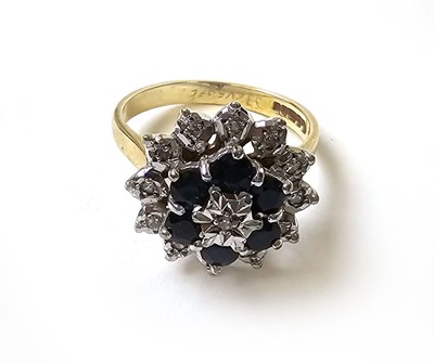 Lot 504 - A 9ct gold, diamond and sapphire cluster ring,...