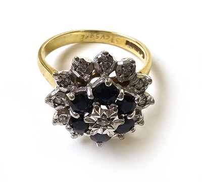 Lot 504 - A 9ct gold, diamond and sapphire cluster ring,...