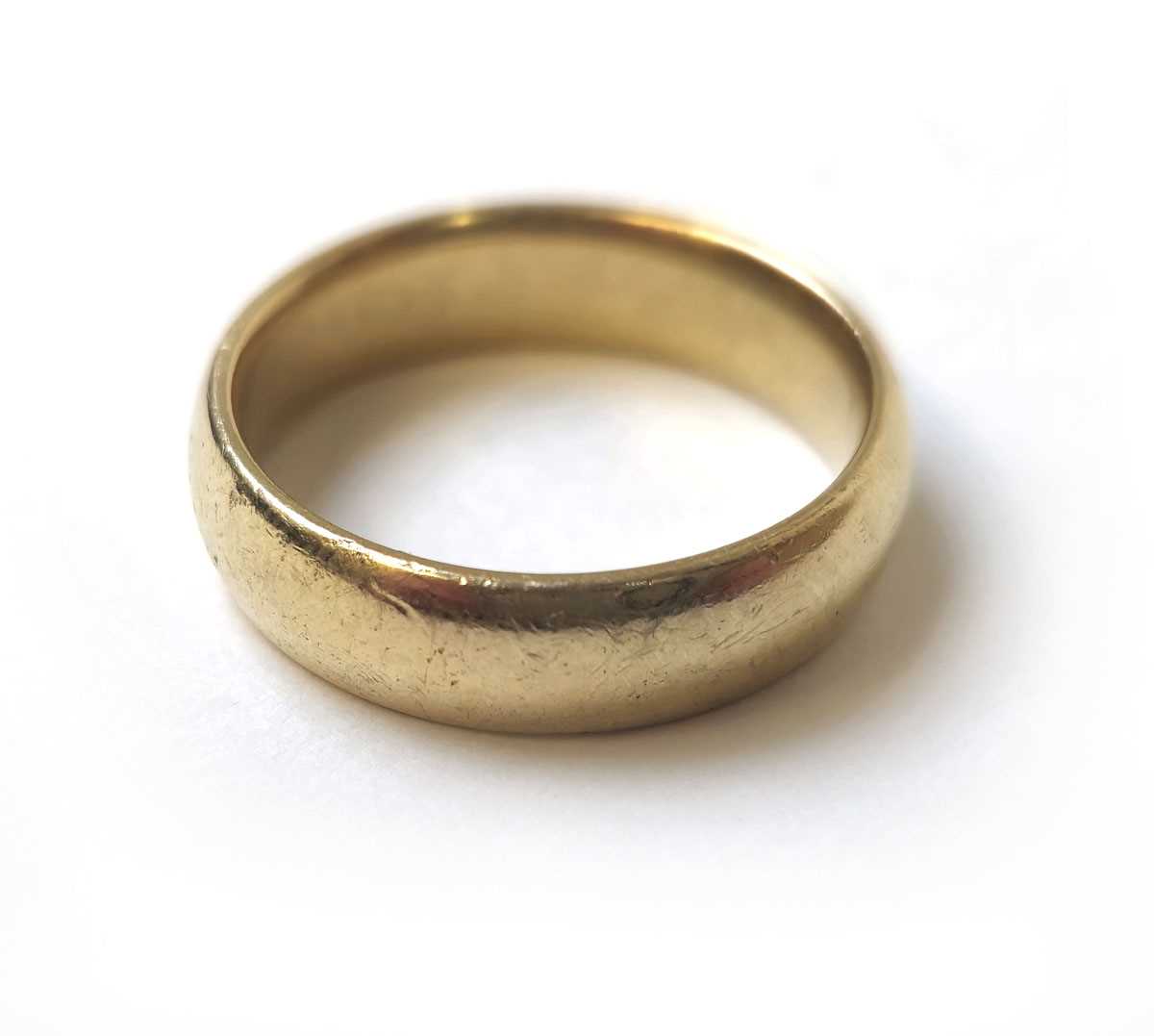 Lot 506 - A yellow metal, court shaped wedding band...