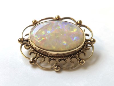 Lot 512 - A 9ct gold and opal brooch with scrolling...