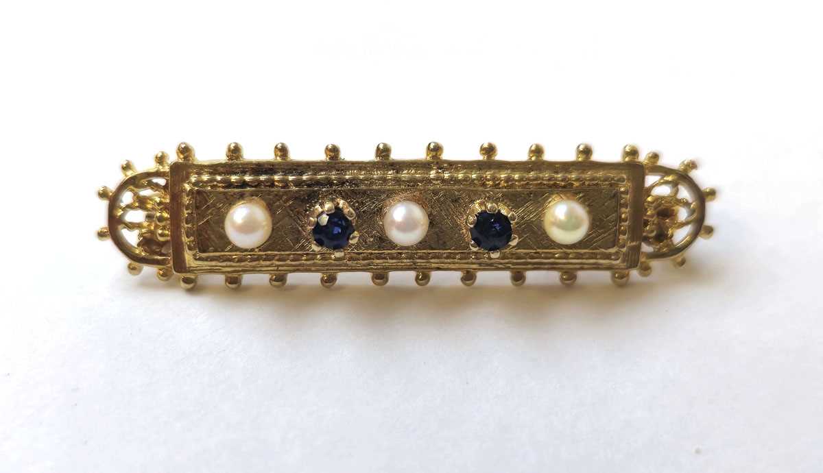 Lot 513 - A 9ct gold, sapphire and pearl set bar brooch....