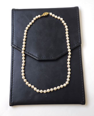 Lot 546 - A single strand pearl necklace with yellow...