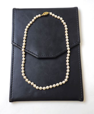 Lot 546 - A single strand pearl necklace with yellow...