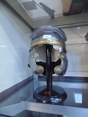 Lot 301 - A reproduction Roman soldier's helmet on stand