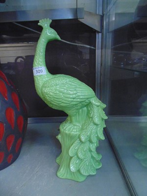 Lot 309 - A green ground ceramic figure of a peacock