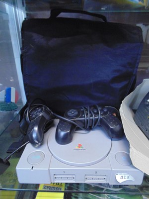 Lot 412 - A Sony Playstation console with two...