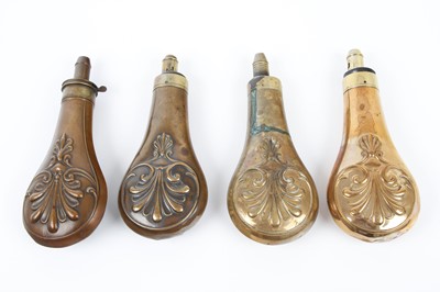 Lot 14 - Four embossed brass powder flasks with similar...