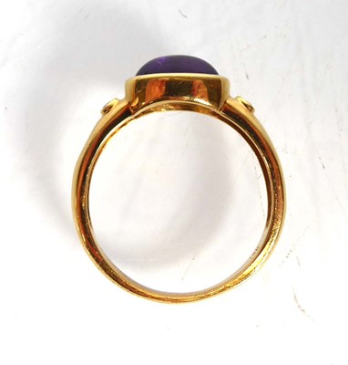 Lot An 18ct yellow gold ring set oval cabochon...