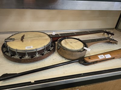 Lot 334 - A five string banjo along with a smaller eight...