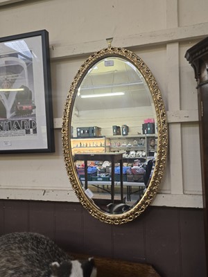 Lot 55 - A reproduction ornate gilt framed oval wall...