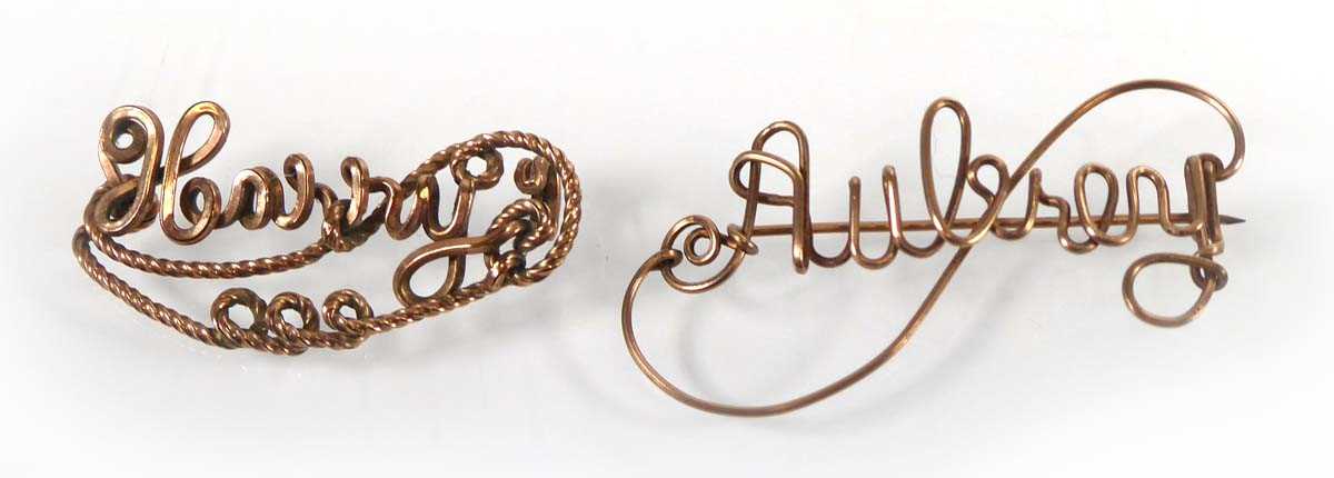 Lot A yellow metal brooch reading 'Aubrey', w. 4.5...