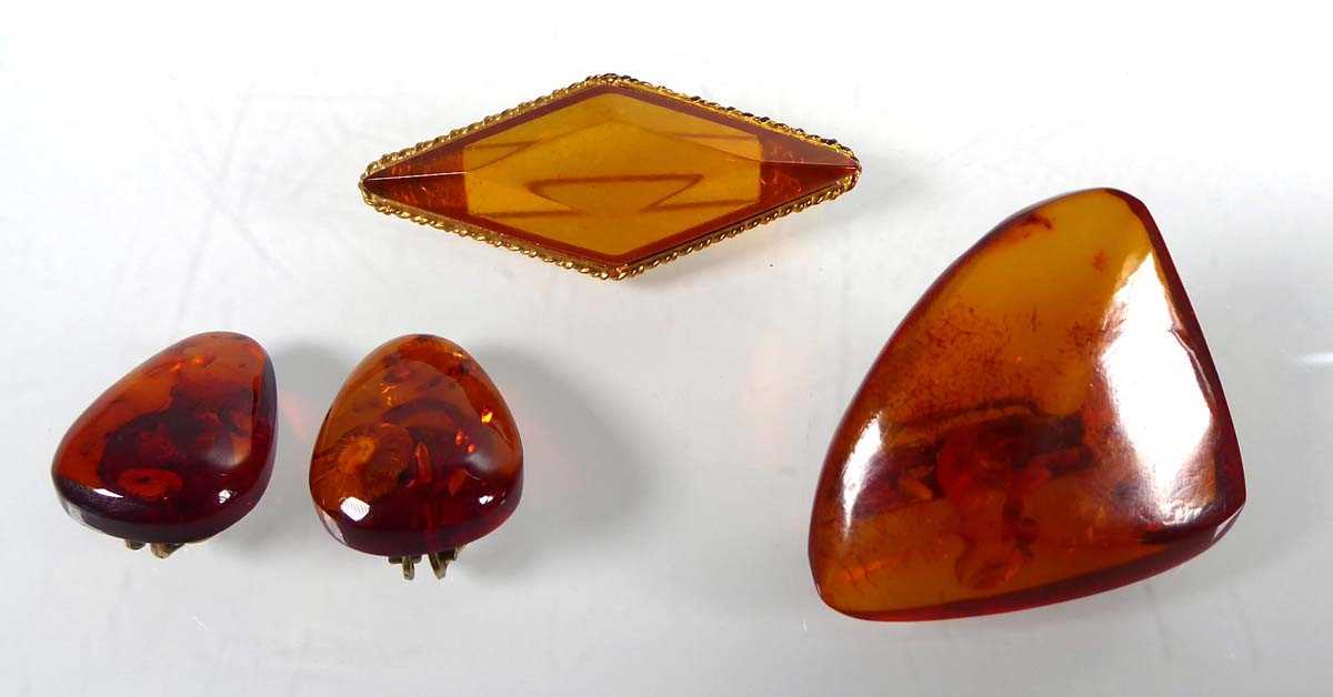 Lot Two amber type brooches, one in a gilt metal...