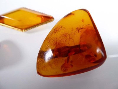 Lot Two amber type brooches, one in a gilt metal...