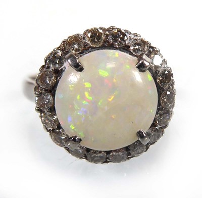 Lot A white metal ring set round opal within a...