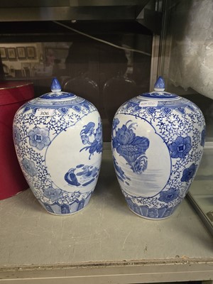 Lot 306 - Two oriental blue and white lidded urns with...