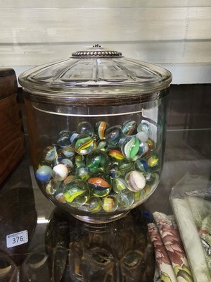 Lot 373 - A glass lidded pot containing an assortment of...