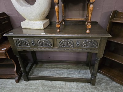 Lot 68 - A mid-20th century side table with two carved...