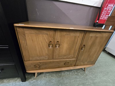 Lot 143 - A light Ercol sideboard having three doors and...