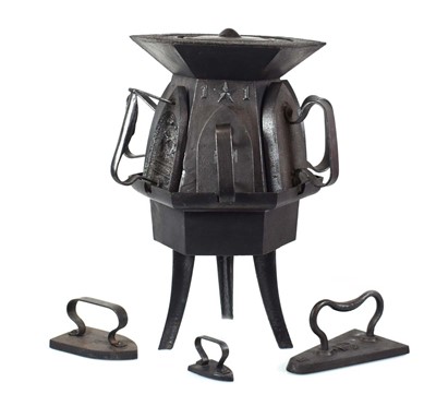 Lot 126 - A cast metal stove holding eight irons, h. 46 cm