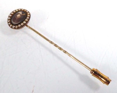 Lot 539 - A yellow metal stickpin set an oval memory...