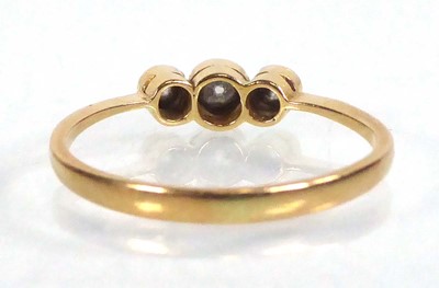 Lot 555 - An 18ct yellow gold ring set three small...