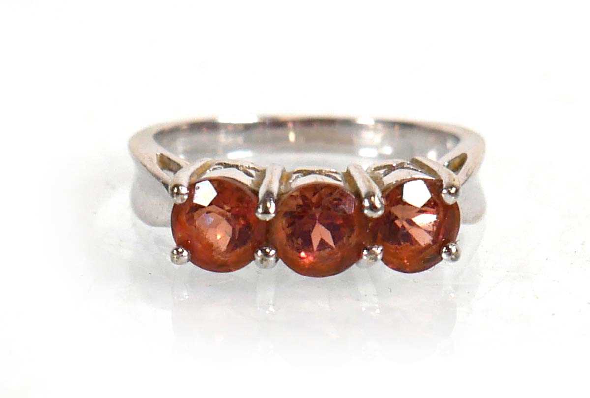 Lot 572 - A 9ct white gold ring set three pale orange...