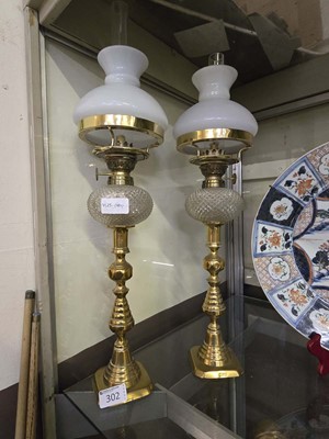 Lot 302 - A pair of ornate brass and glass oil lamps,...