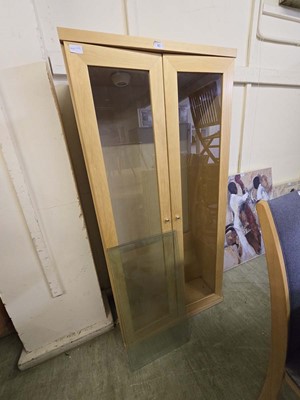 Lot 40 - A beech effect glazed two door cabinet with...