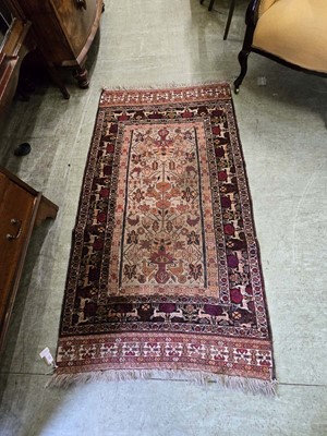 Lot 65 - A rectangular eastern red ground rug