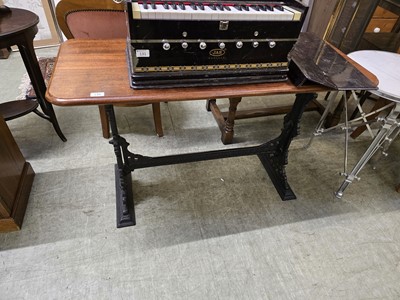 Lot 130 - A cast iron based table with mahogany top