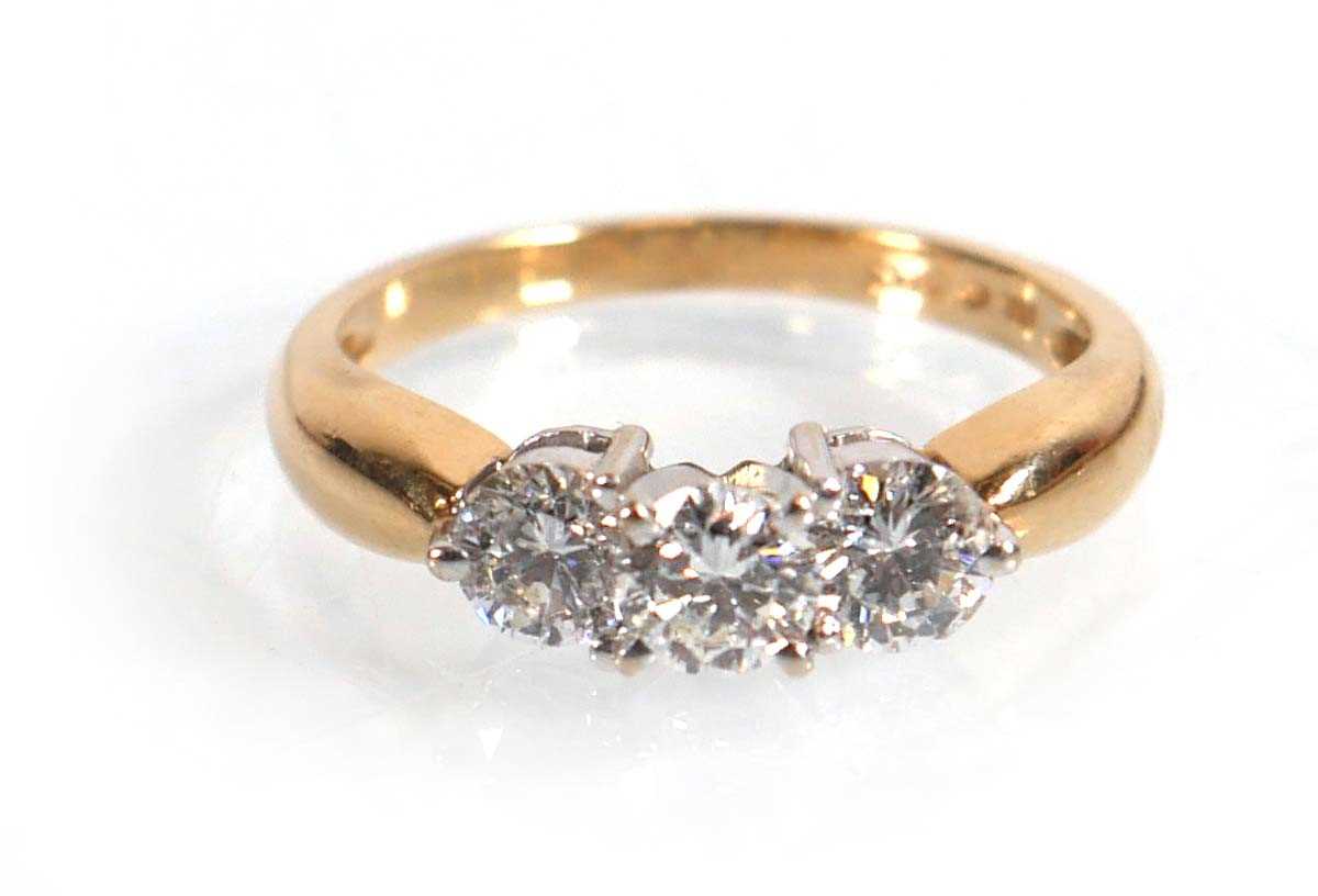 Lot 608 - A 14ct yellow gold ring set three brilliant...