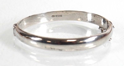 Lot 656 - A silver scroll engraved hinged bracelet,...