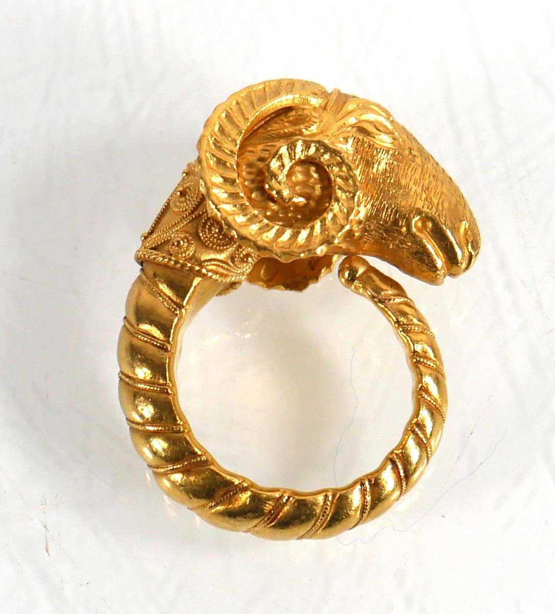 Lot A yellow metal ring in the form of a rams head...