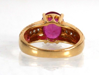 Lot 671 - An 18ct yellow gold ring set oval ruby in a...