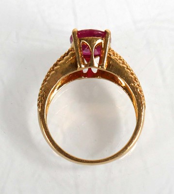 Lot 671 - An 18ct yellow gold ring set oval ruby in a...