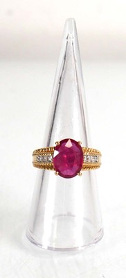 Lot 671 - An 18ct yellow gold ring set oval ruby in a...