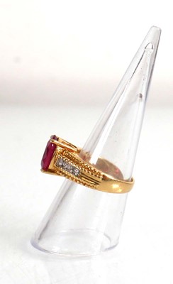 Lot 671 - An 18ct yellow gold ring set oval ruby in a...