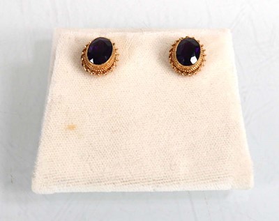 Lot 679 - A pair of 9ct yellow gold ear studs, each set...