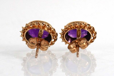 Lot 679 - A pair of 9ct yellow gold ear studs, each set...